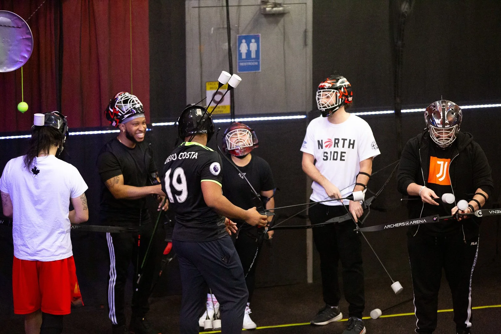 Corporate team strategizing during combat archery at Archers Arena Toronto