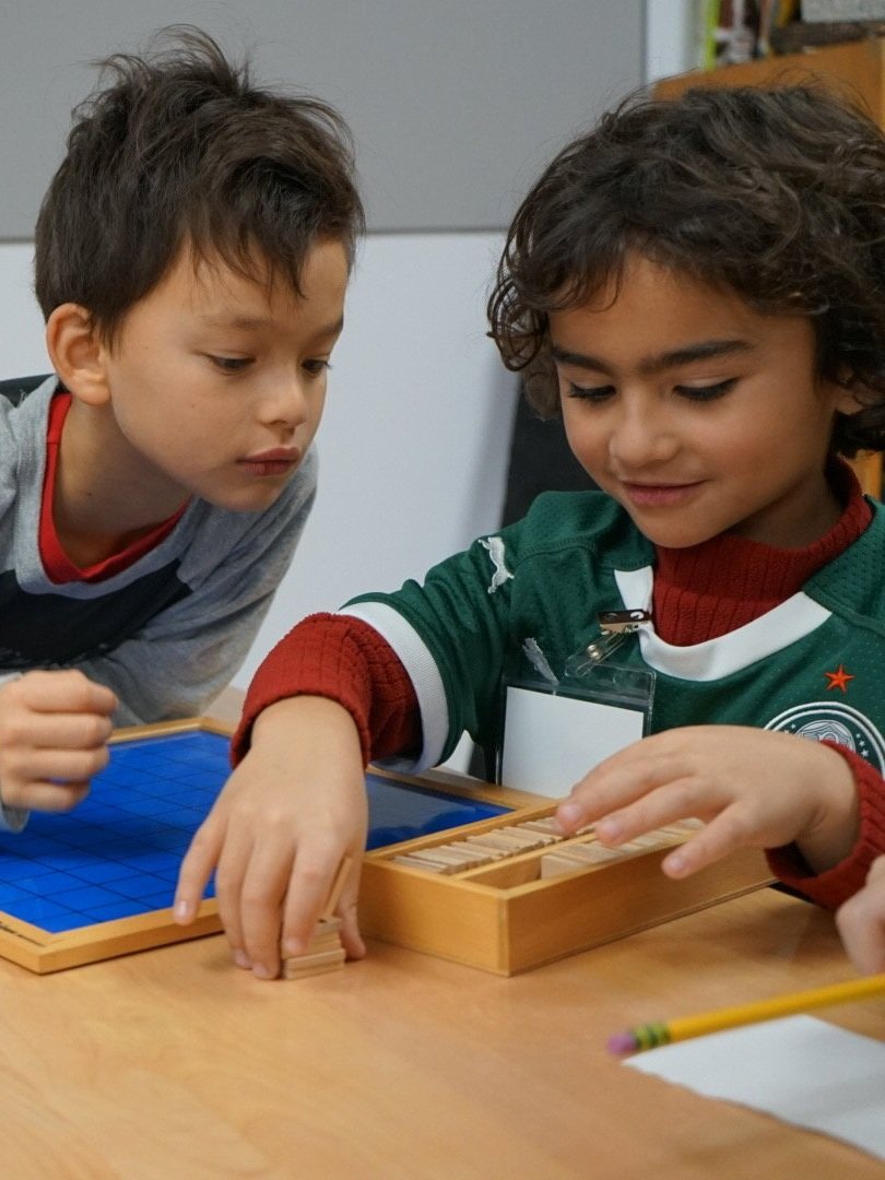 Lower Elementary students using Montessori materials