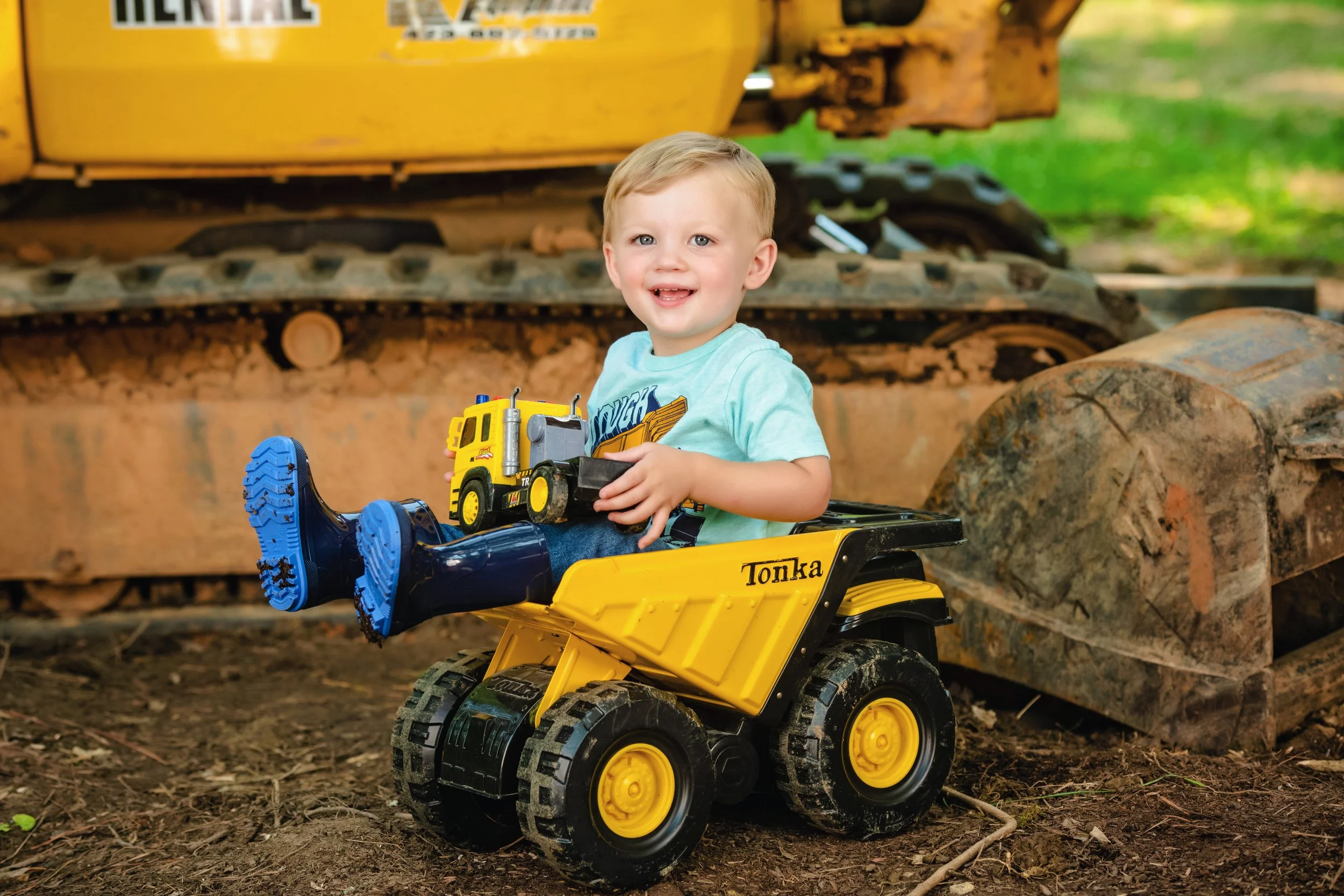 Child playing with a toy truck in the mud