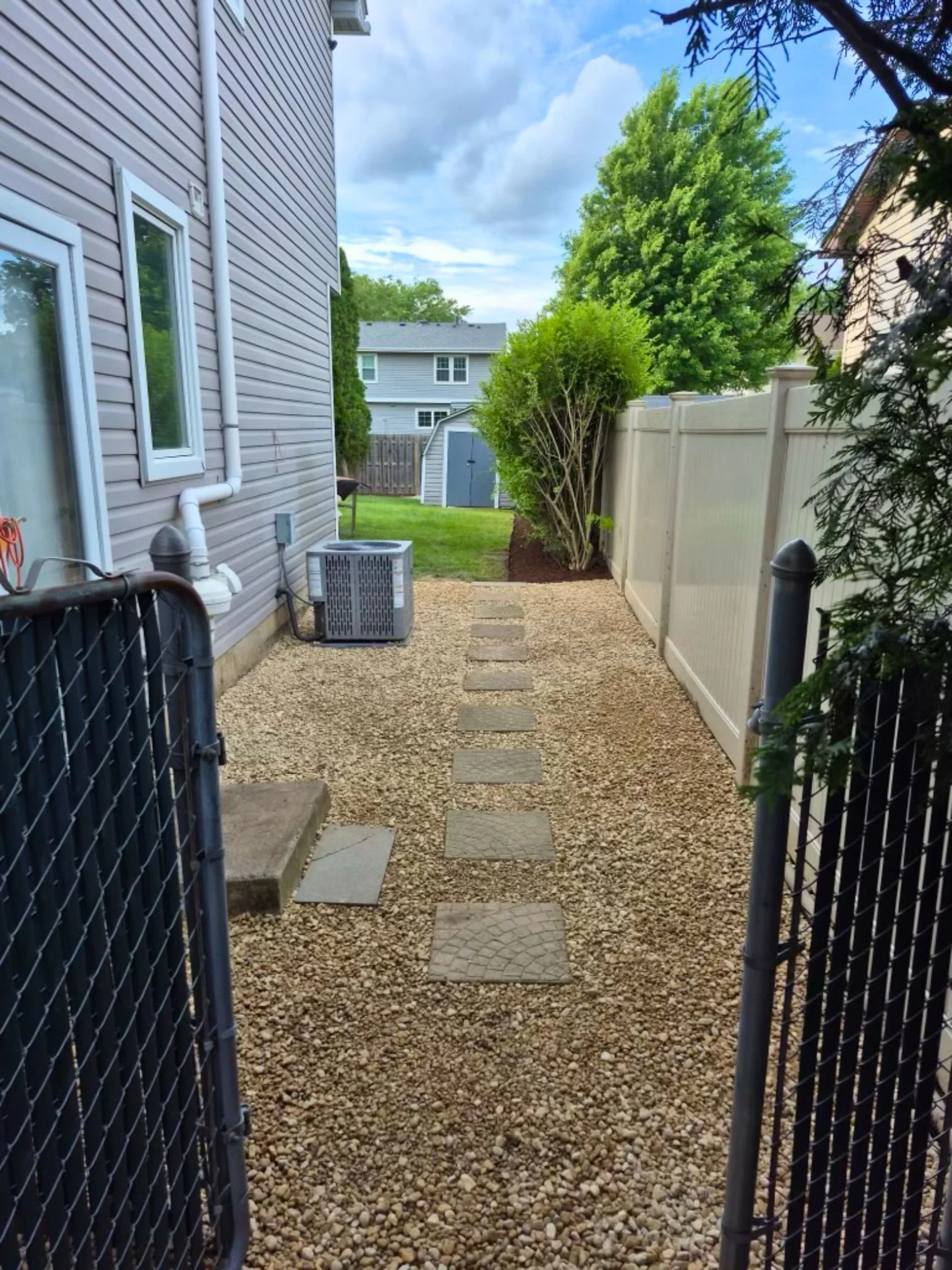 Stepping stones through the finished river rock side yard in Bloomingdale, Illinois.