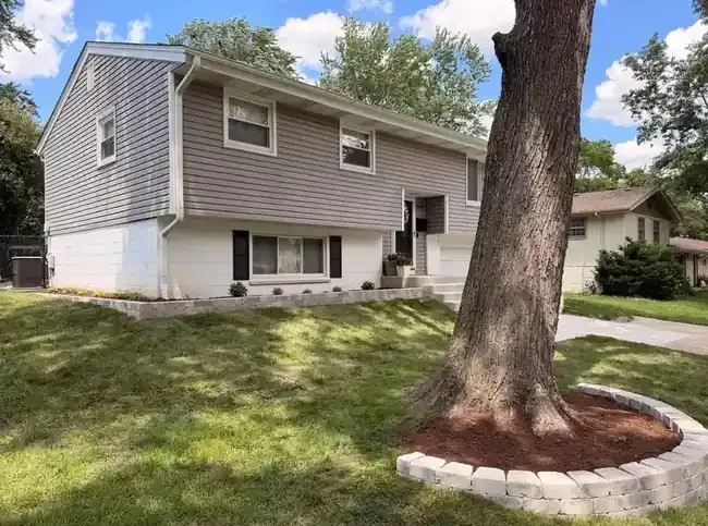 Wide view of front-yard retaining wall tree ring sod in Schaumburg, Illinois.