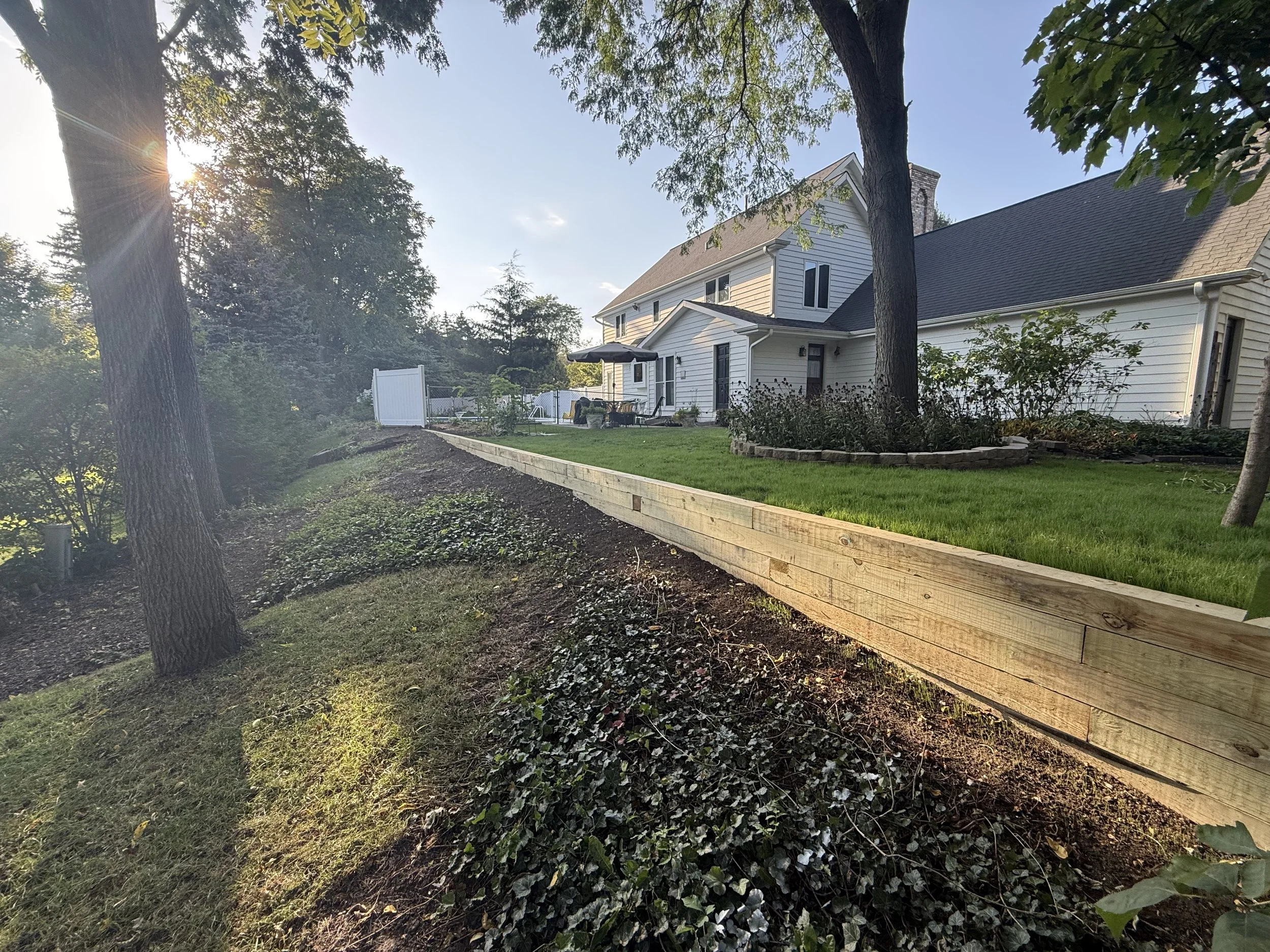 Finished timber retaining wall and drainage installation by Home Pride Landscape & Design in Roselle, Illinois.
