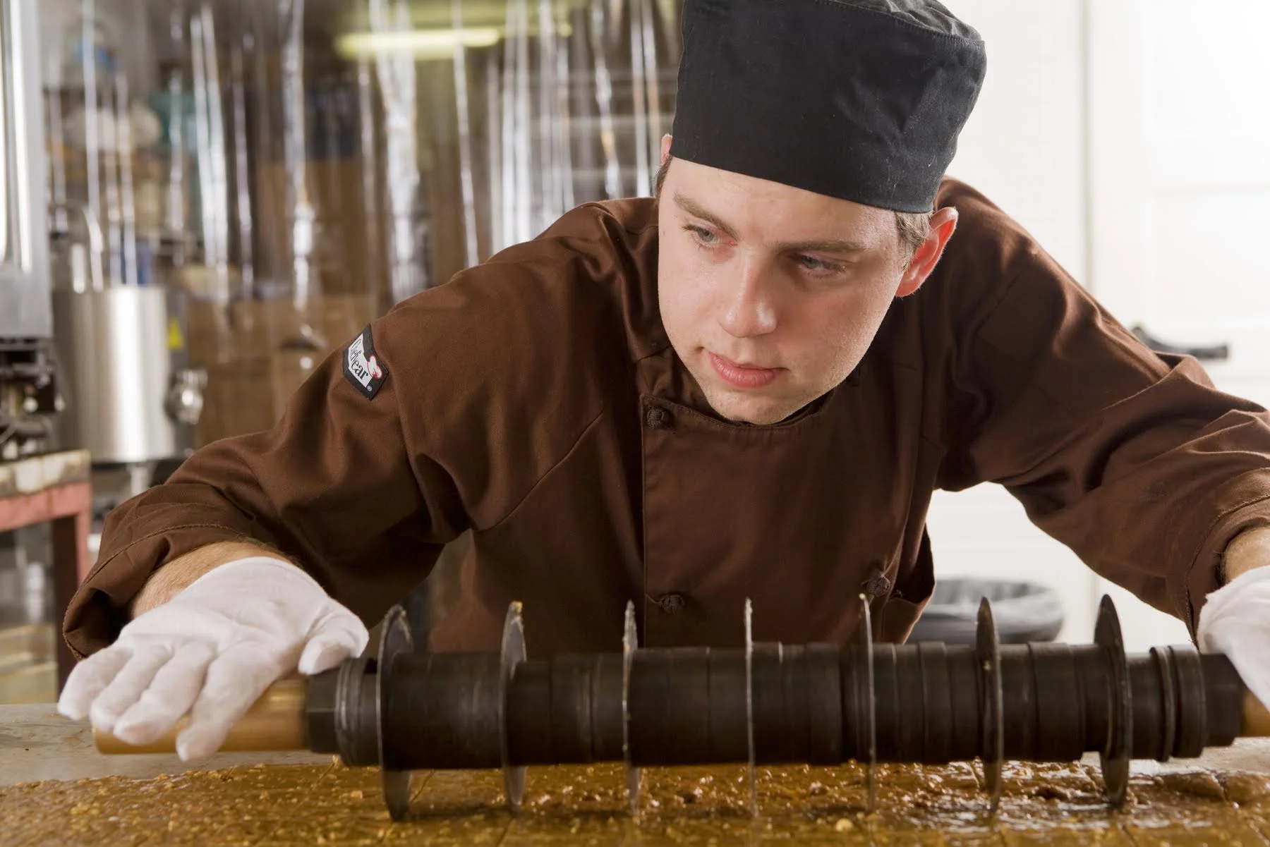 Chocolatier shaping confectionery on a work surface in the Wiseman House Chocolates studio