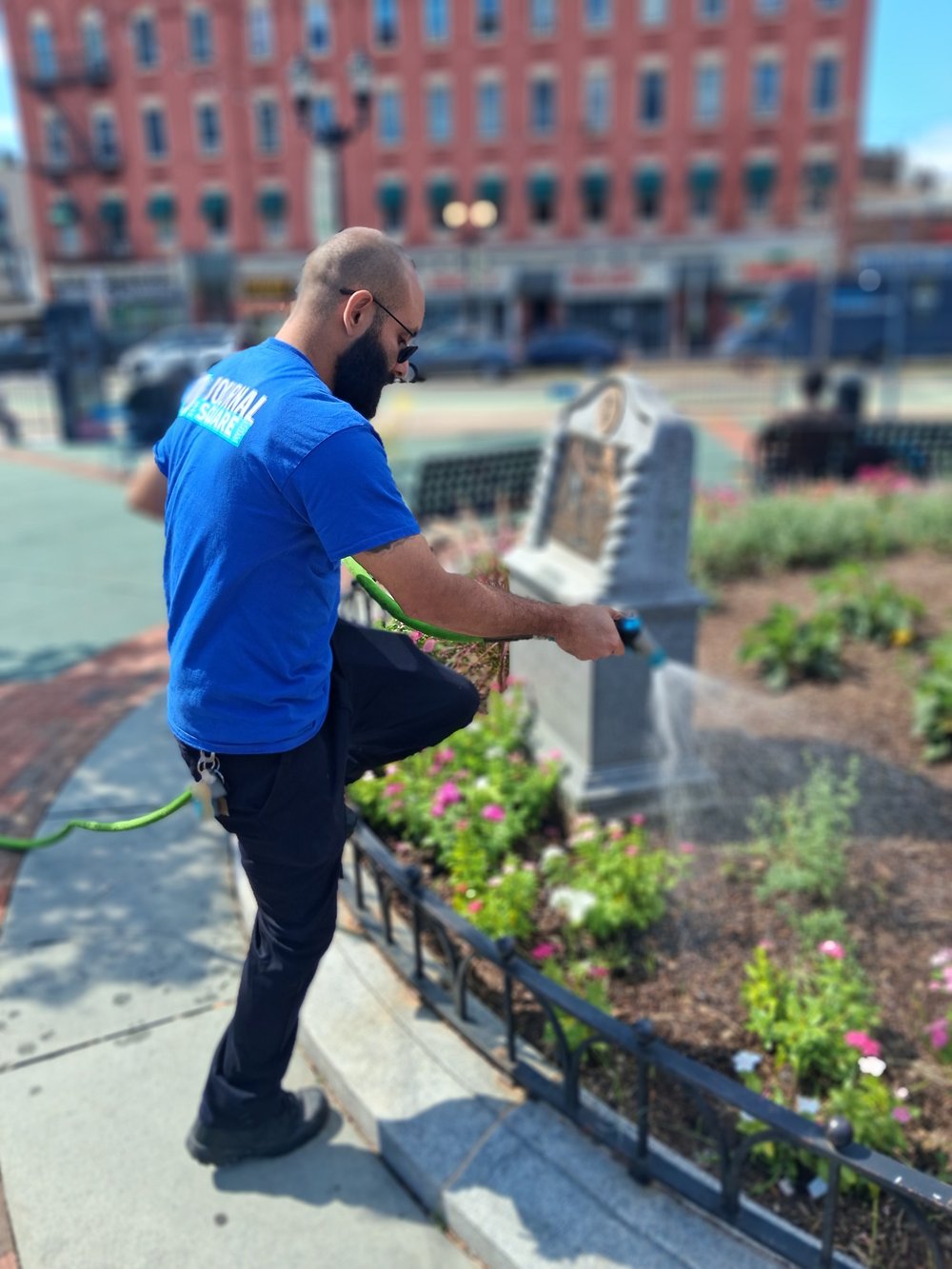 A crew member tending the plaza garden