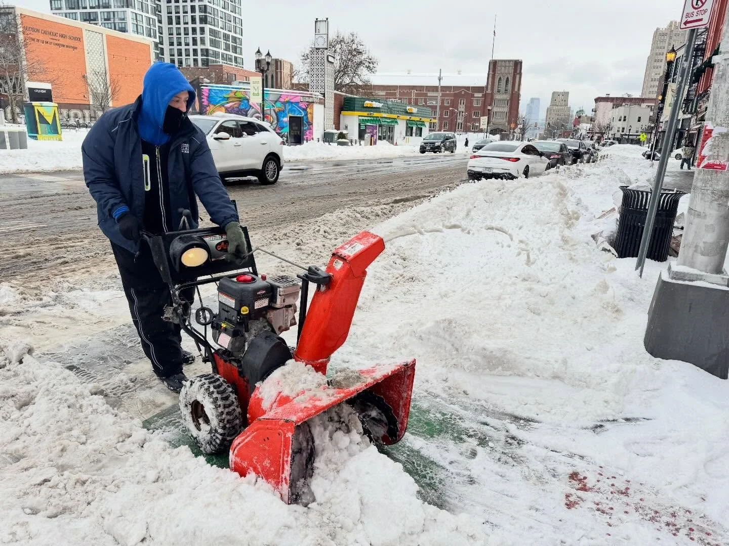 A CDS crew member clearing snow with a snow blower in McGinley Square