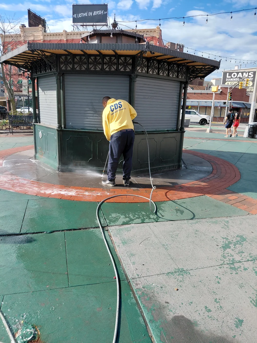 CDS crew power washing by the McGinley Square kiosk