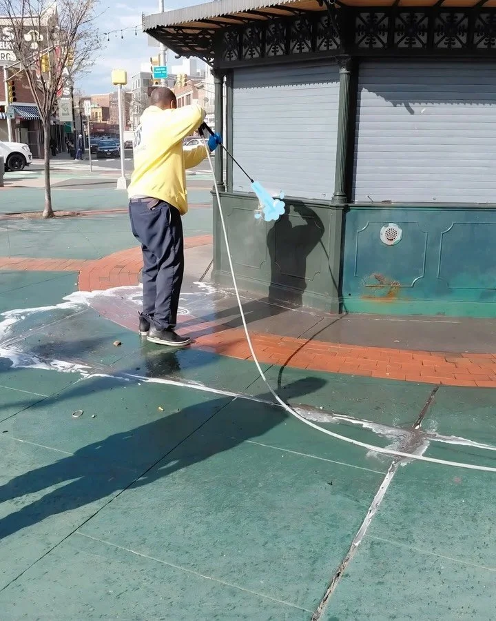 A CDS crew member power washing by the kiosk