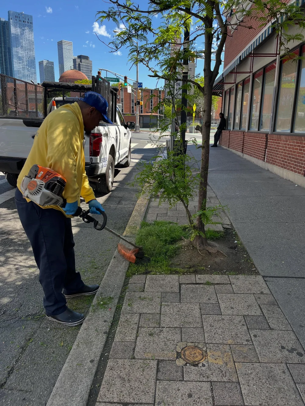 CDS crew member weed whacking in McGinley Square