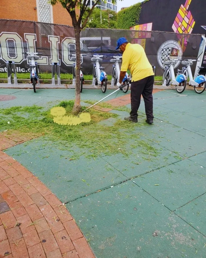 A CDS crew member weed whacking along the plaza
