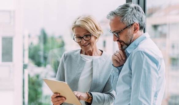 A man and woman in thought looking at a tablet
