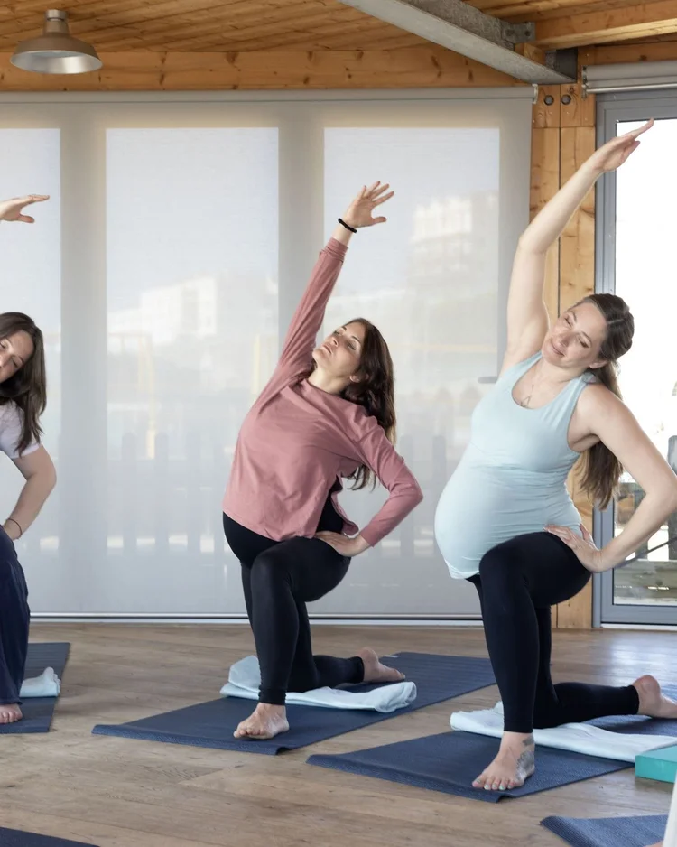 Pregnant women practising a standing side stretch