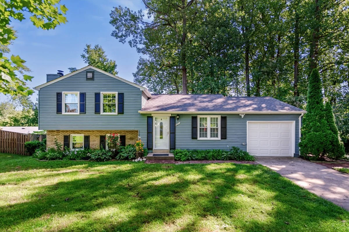 Split-level home exterior with mature trees