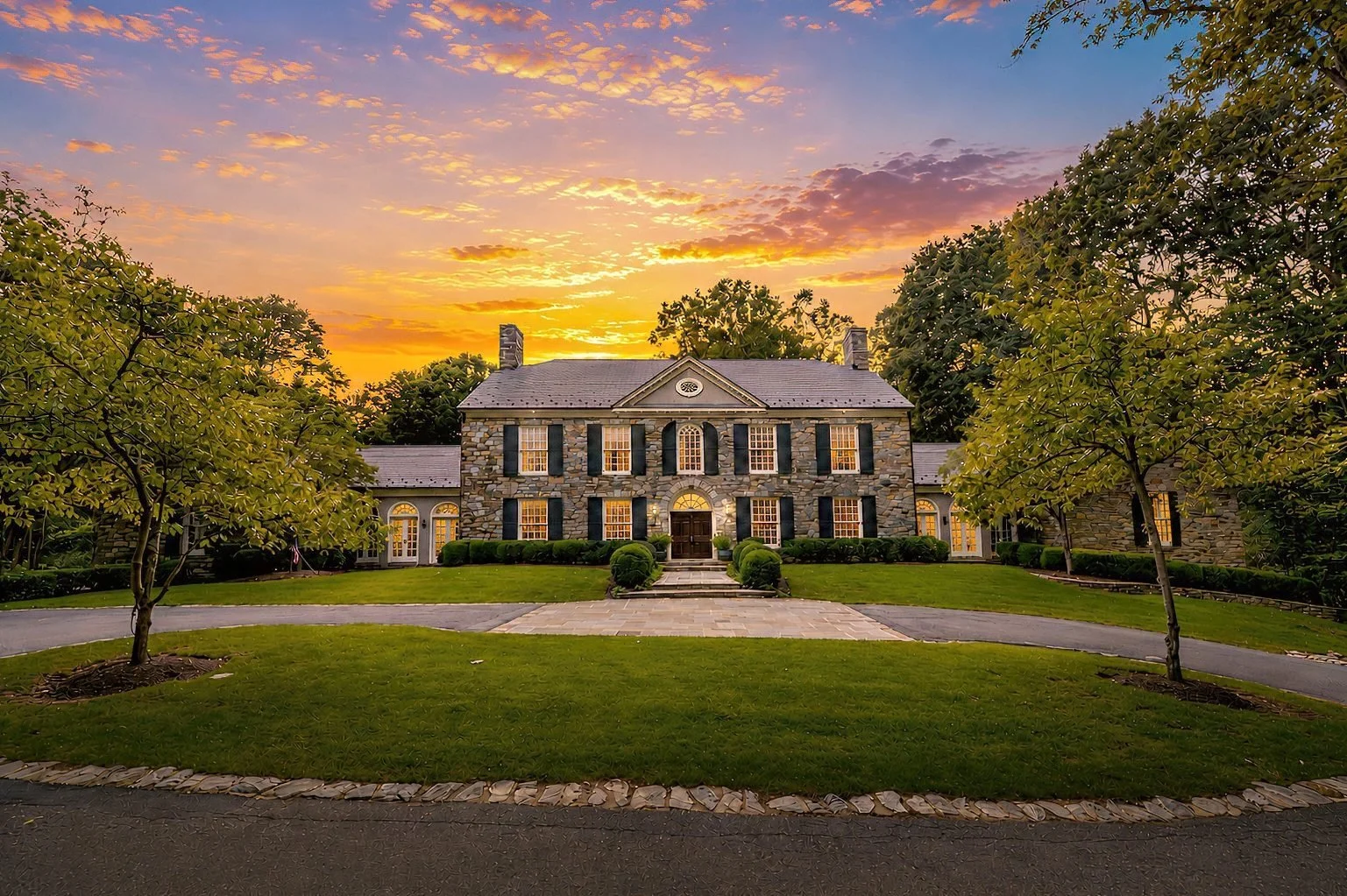 Twilight front exterior of a stone colonial estate photographed by Elite Real Estate Media