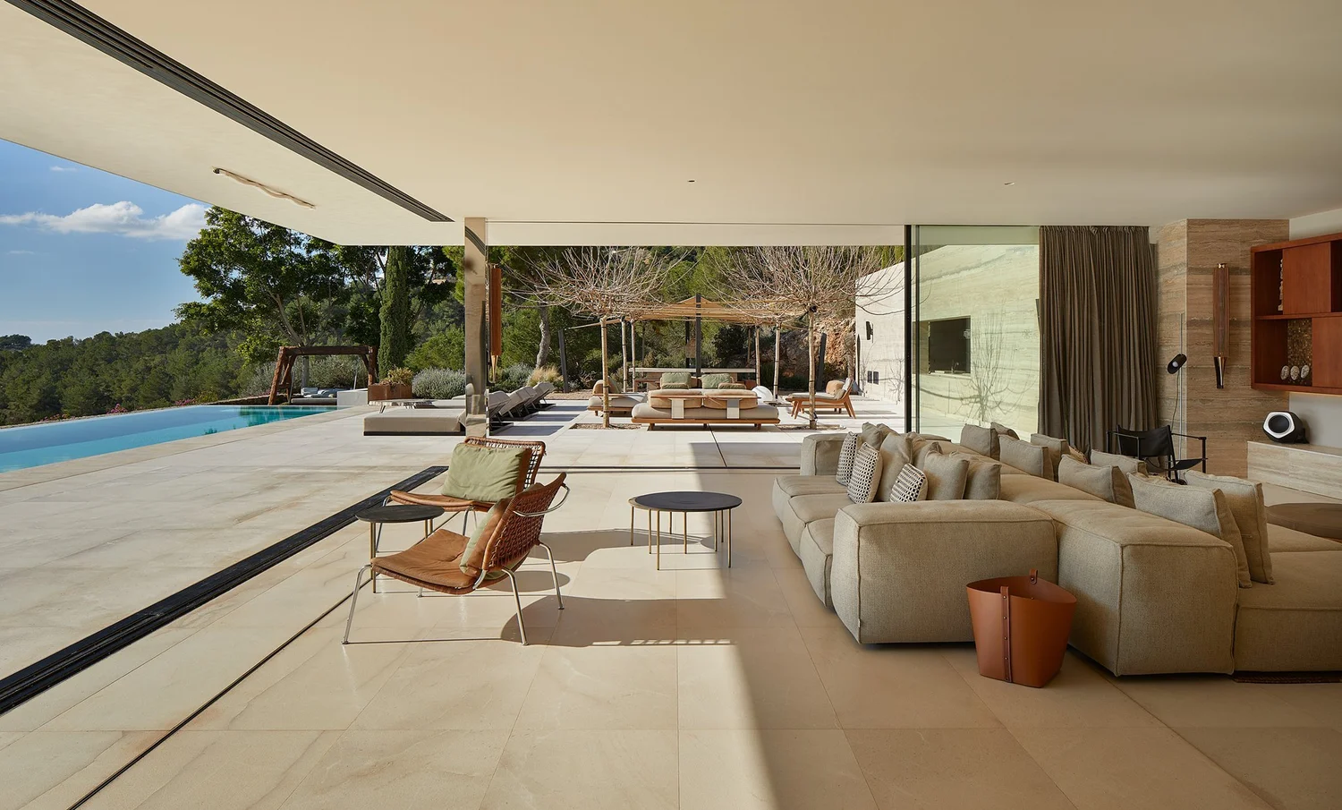 Salón de Can Kef abierto a la terraza, la piscina y el jardín.