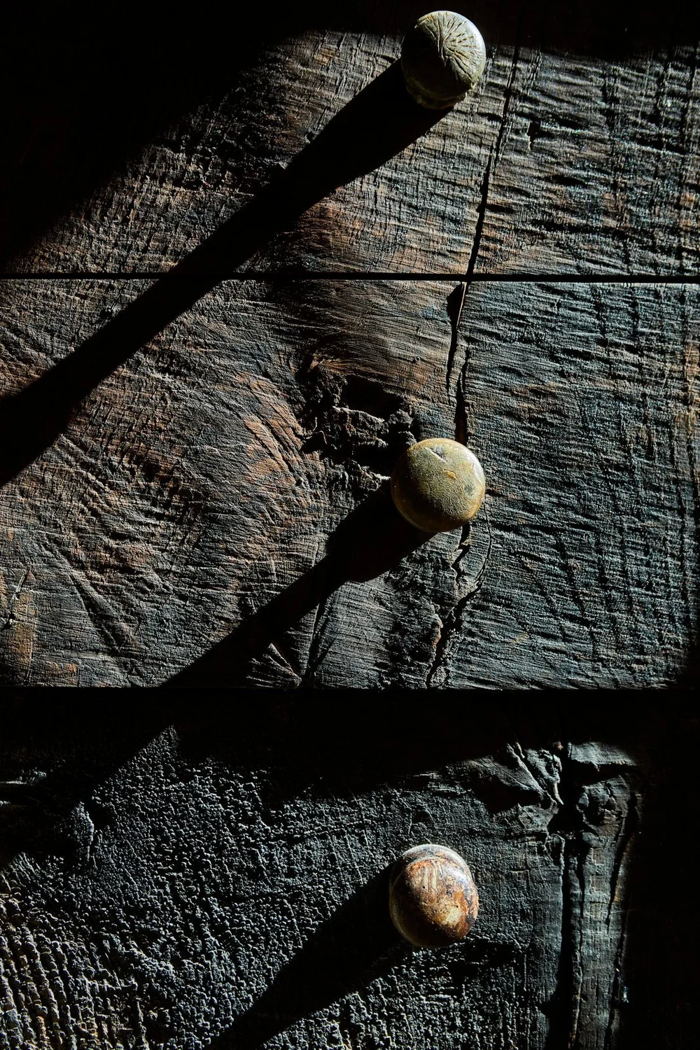 Detalle de una superficie de madera oscura con pequeños elementos claros.