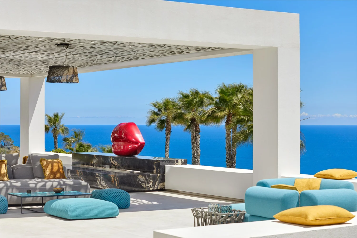 Terraza cubierta con asientos de colores y vistas al mar.