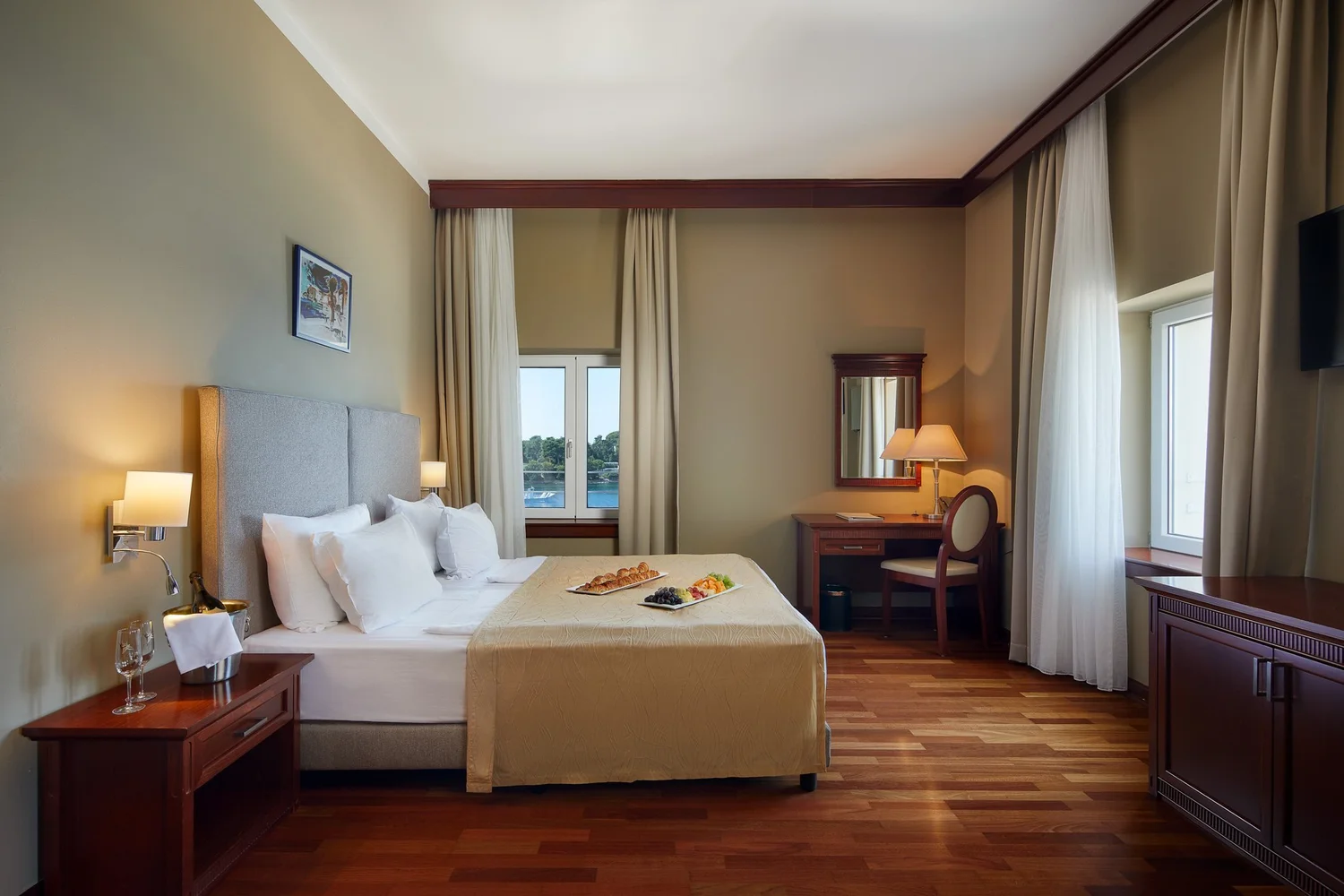 Habitación del hotel con suelo de madera y vistas desde las ventanas.
