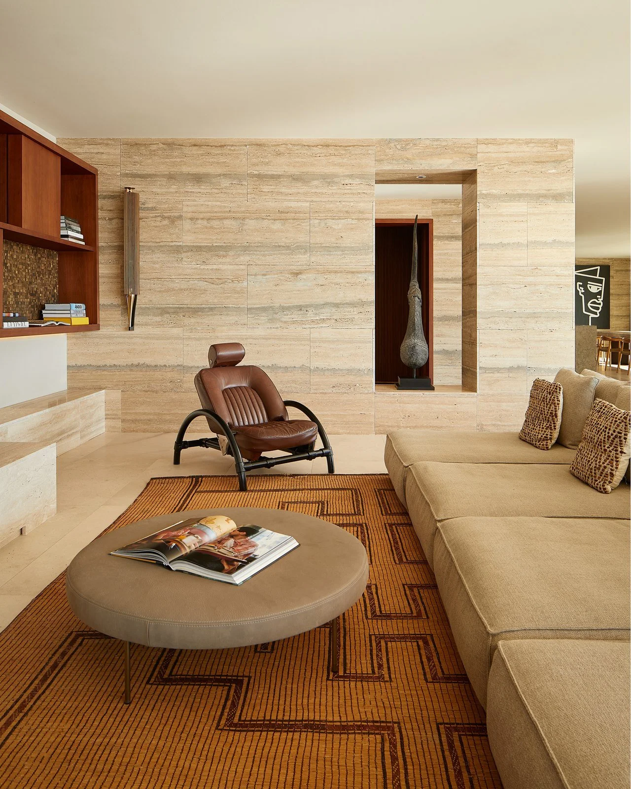 Detalle del salón con butaca de cuero y mesa baja.