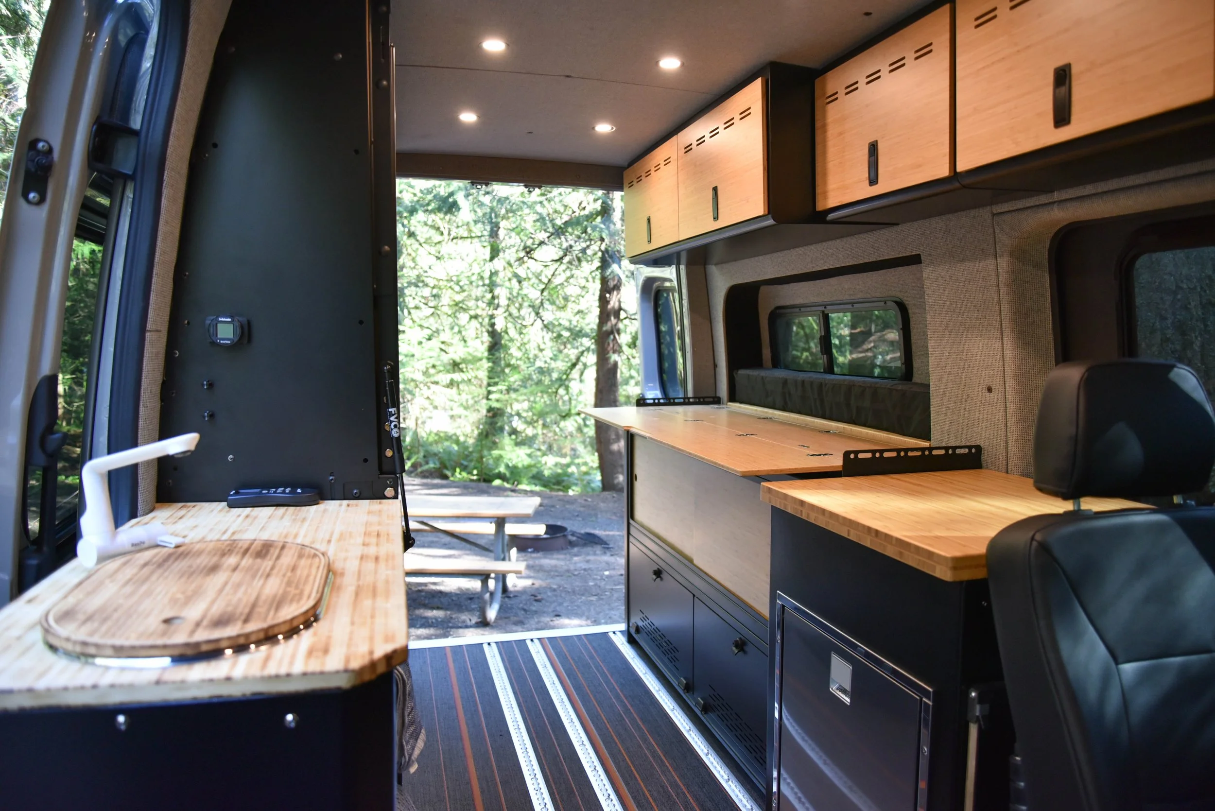 Custom camper van interior with wooden kitchen and cabinets