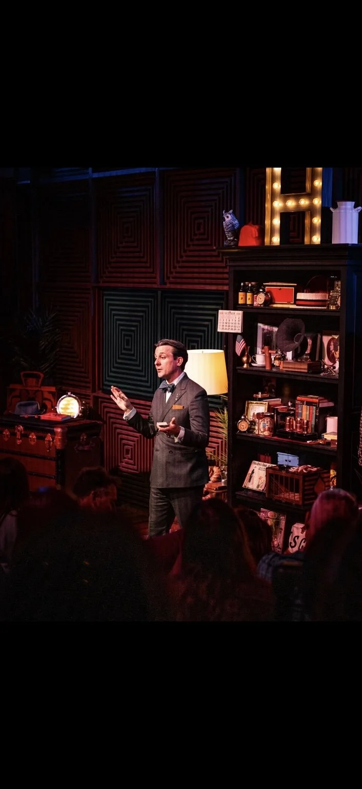 Lee Terbosic portraying Harry Houdini on the Liberty Magic stage beside the living-room bookcase