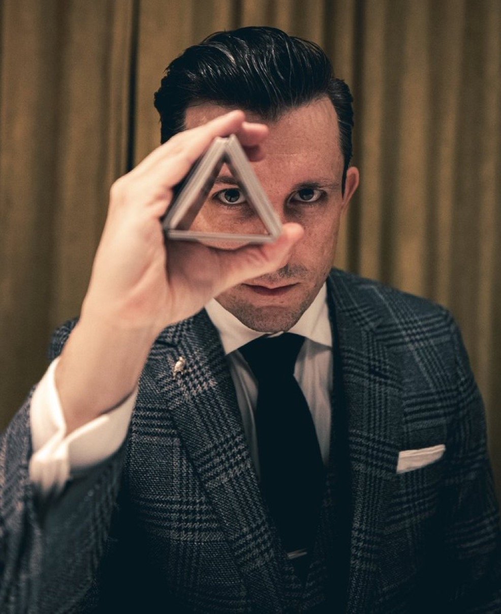Lee Terbosic looking through a triangle of playing cards for In Plain Sleight