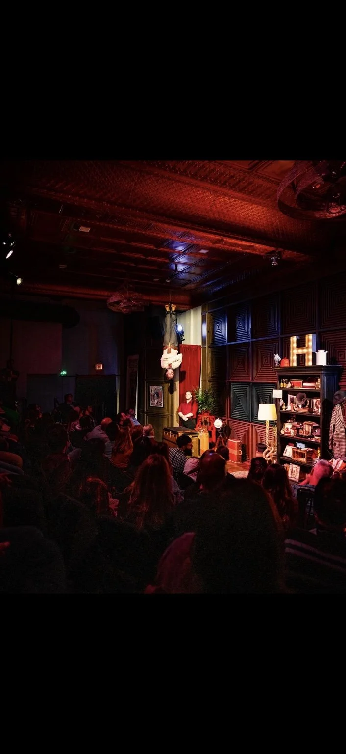Lee Terbosic suspended upside down during The Life and Death of Harry Houdini at Liberty Magic