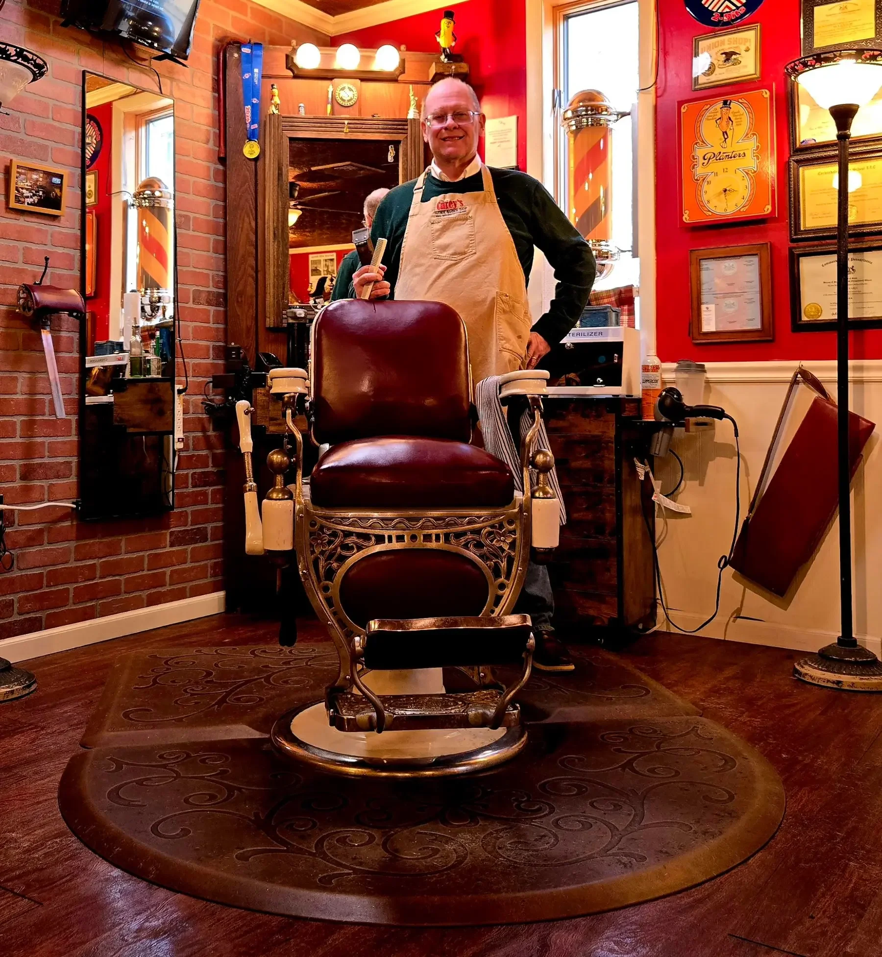 Dan Carey standing behind his vintage barber chair