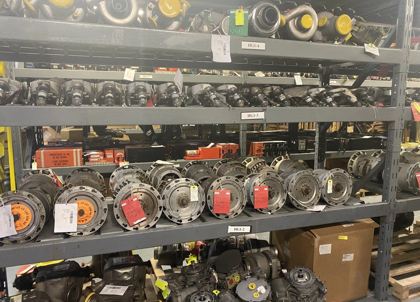 A full rack of starter-generators and turbo parts on labeled bins in the Skylink warehouse