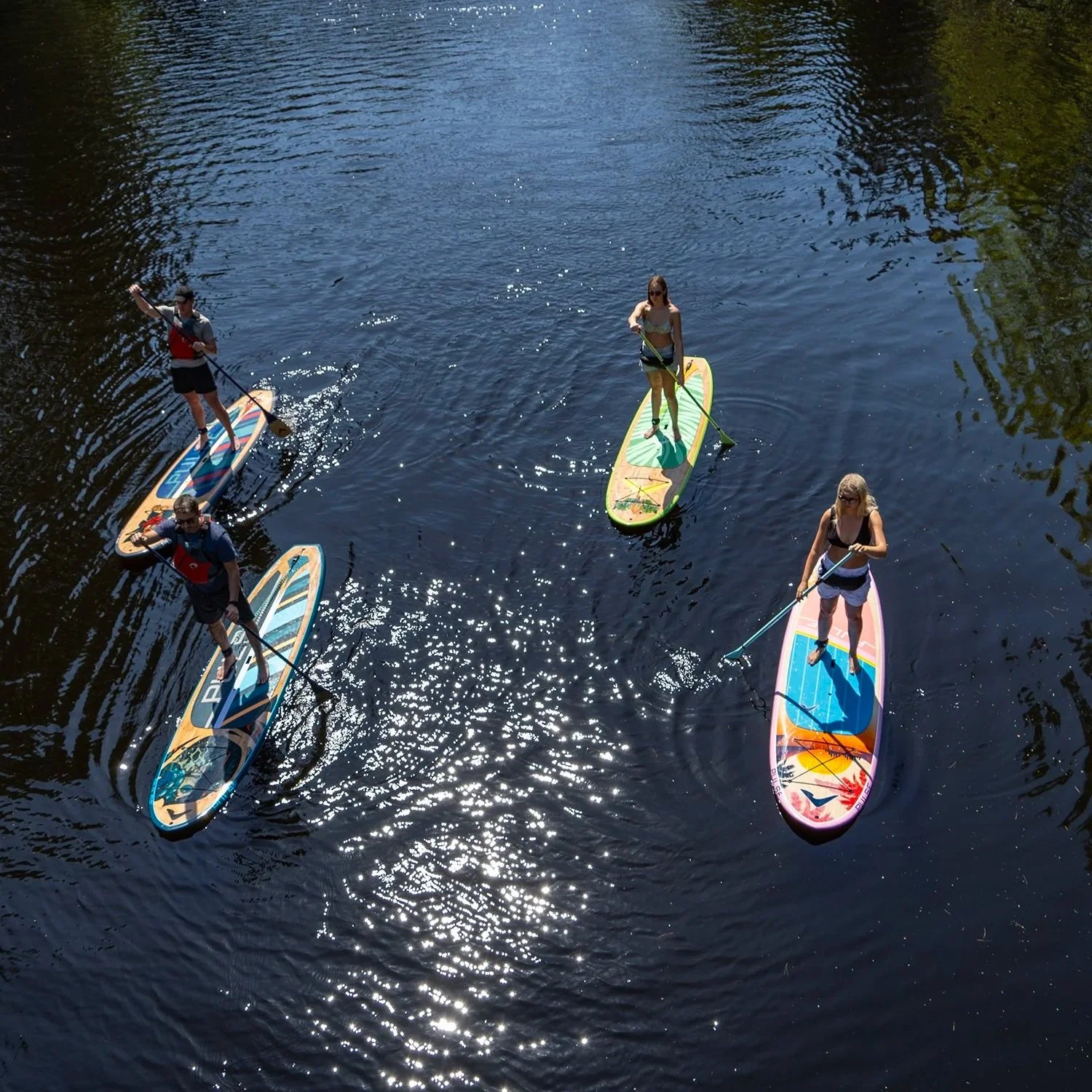 Paddlers on hard stand-up paddle boards