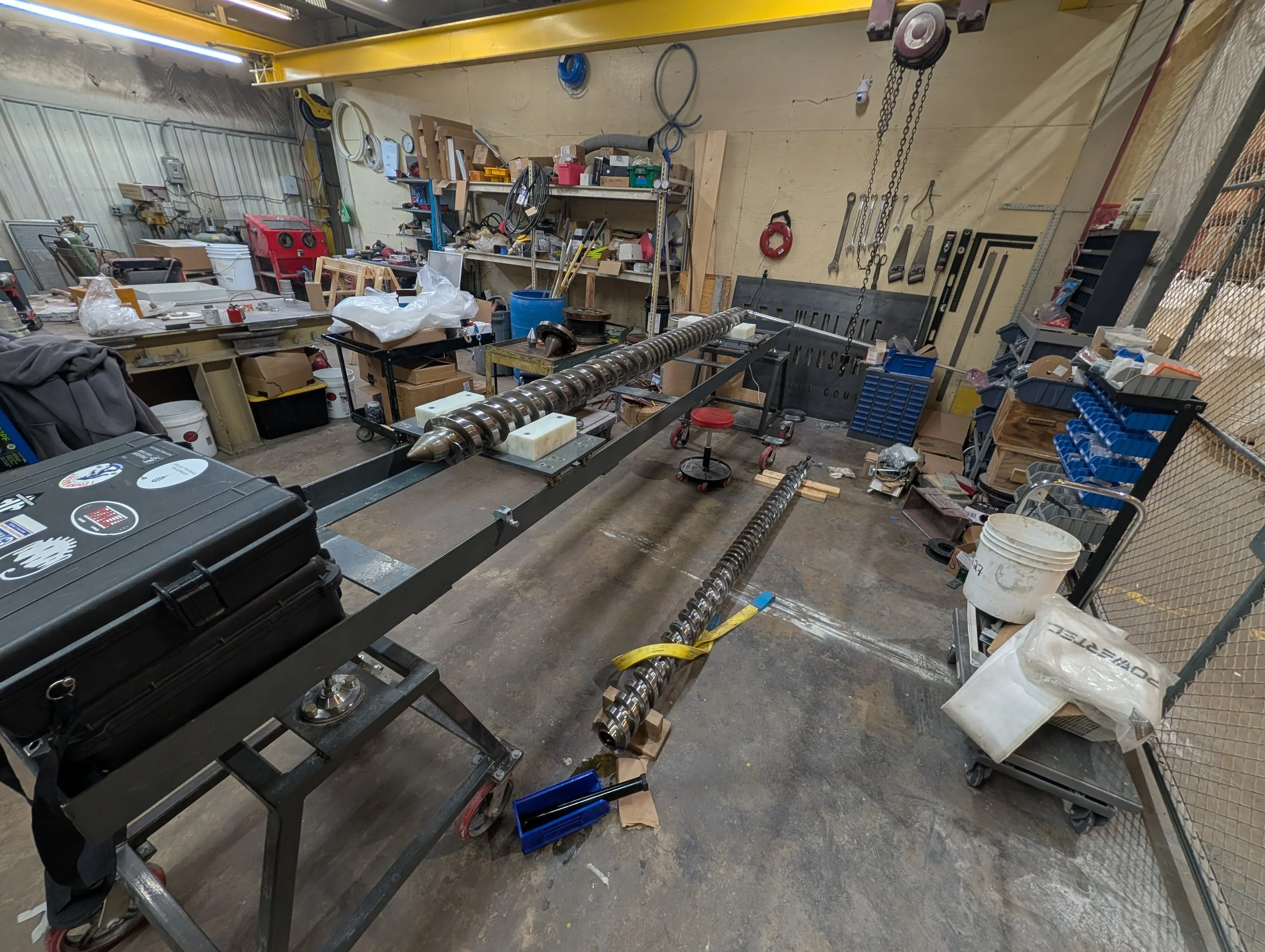 Two damaged counter-rotating twin extrusion screws in the maintenance bay at the client facility prior to scanning