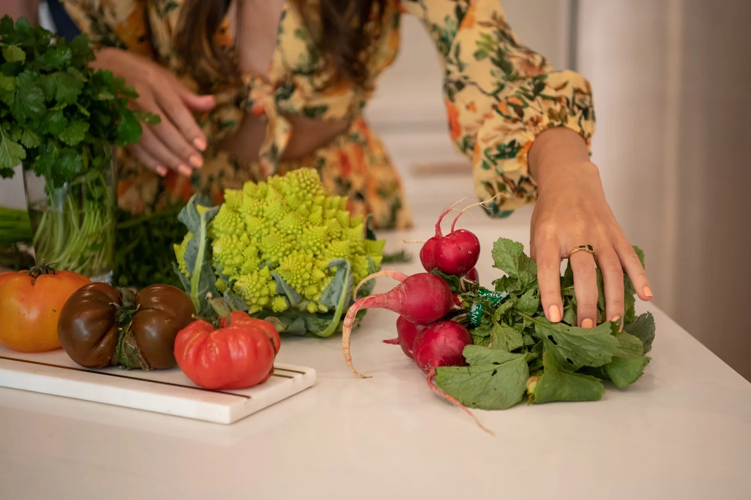 Heirloom tomatoes, romanesco and radishes on a kitchen counter