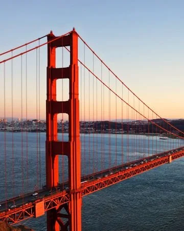 Pont suspendu au soleil couchant au-dessus de l'eau, illustration du passage entre deux mondes