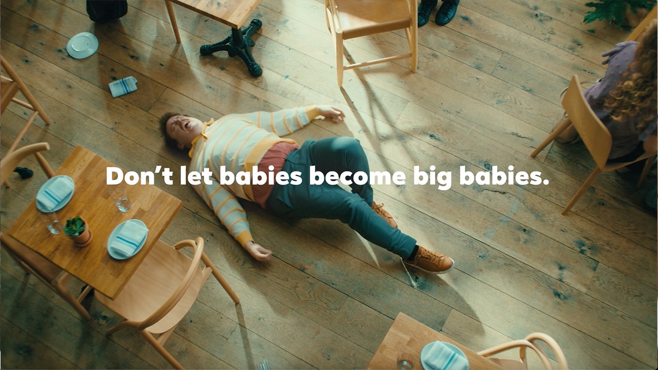 Scott Watson as Big Baby lying on the restaurant floor during a tantrum in the Plum Organics commercial, with the slogan Don't let babies become big babies.