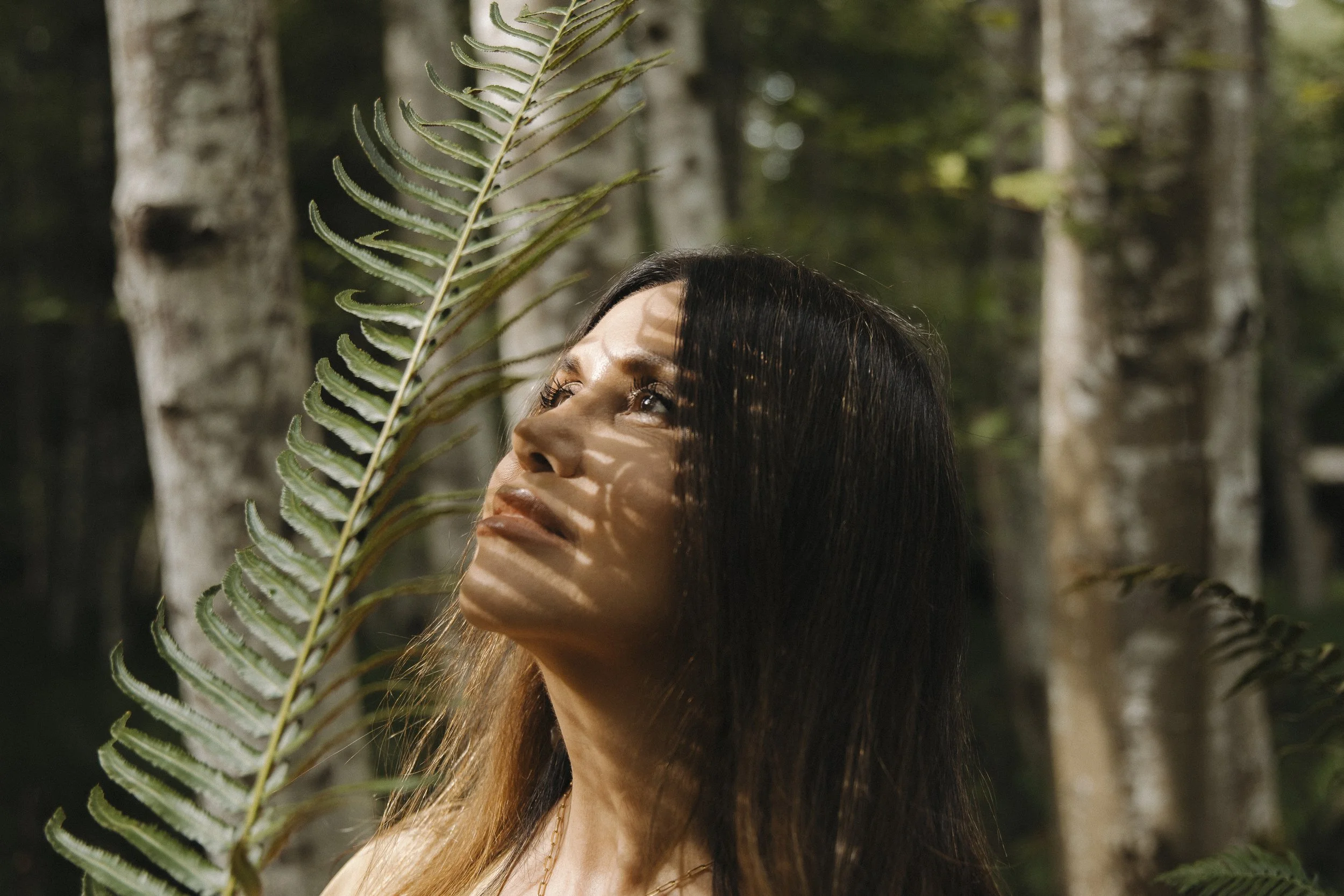 Shehera Barnes standing among the ferns in the forest