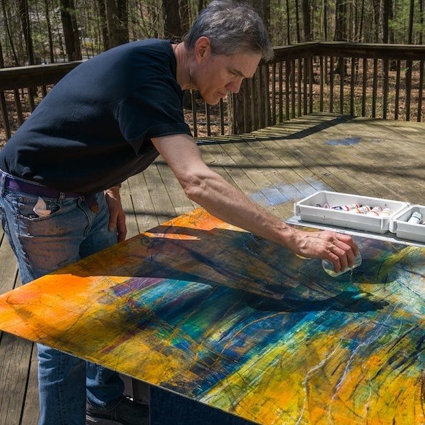 Christopher working on a painting outside