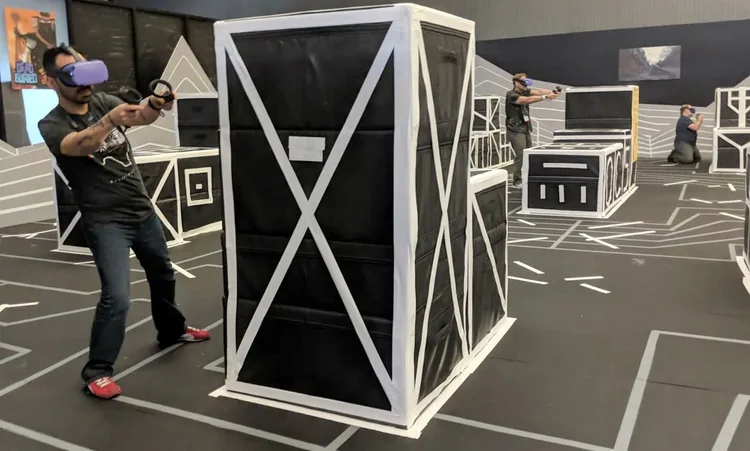 A player aims at an opponent from behind a crate.