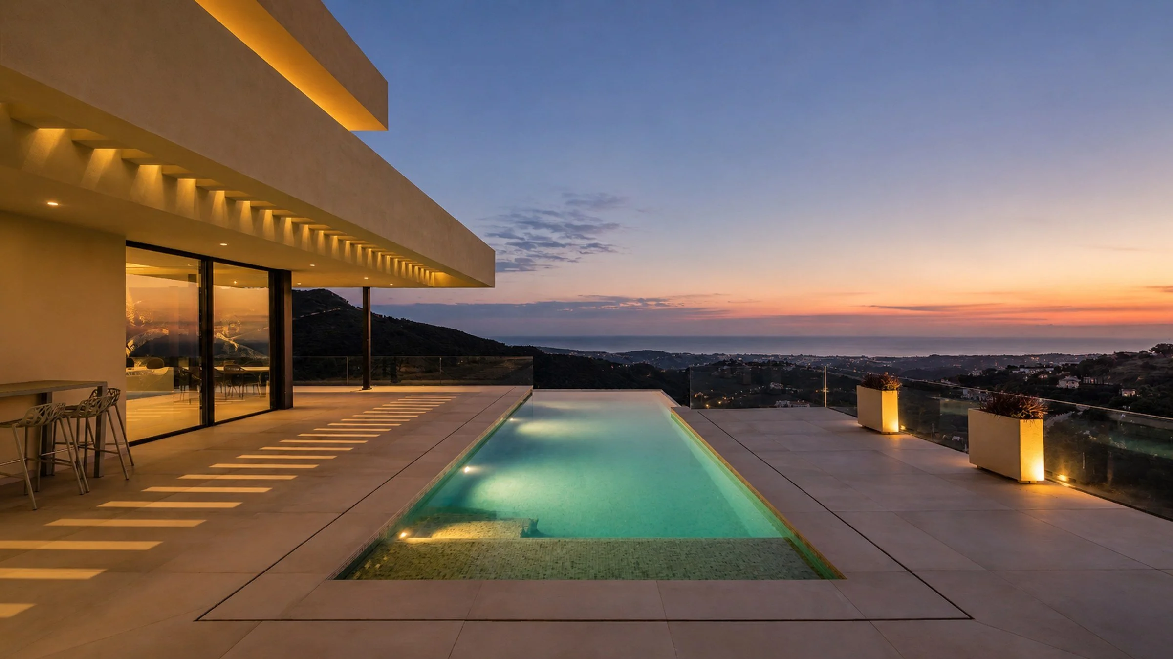 Contemporary villa in Benahavis at dusk with infinity pool overlooking the Marbella coastline