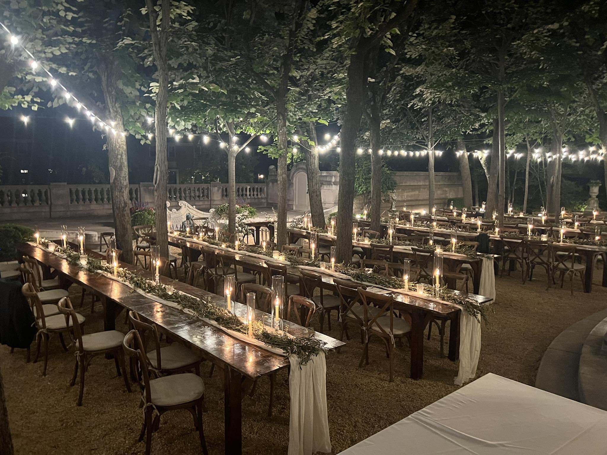 Rustic outdoor event with farmhouse tables and candles