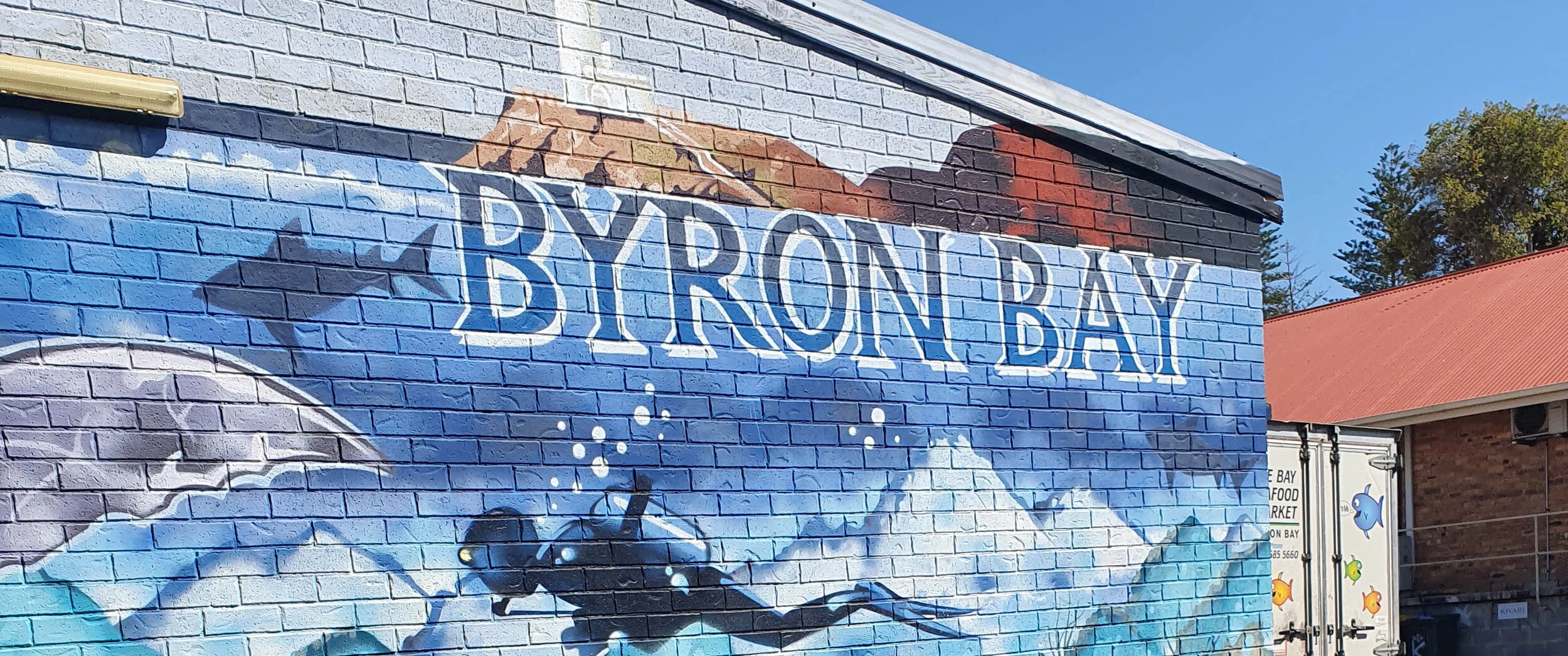 Byron Bay street art mural painted on a brick wall in town