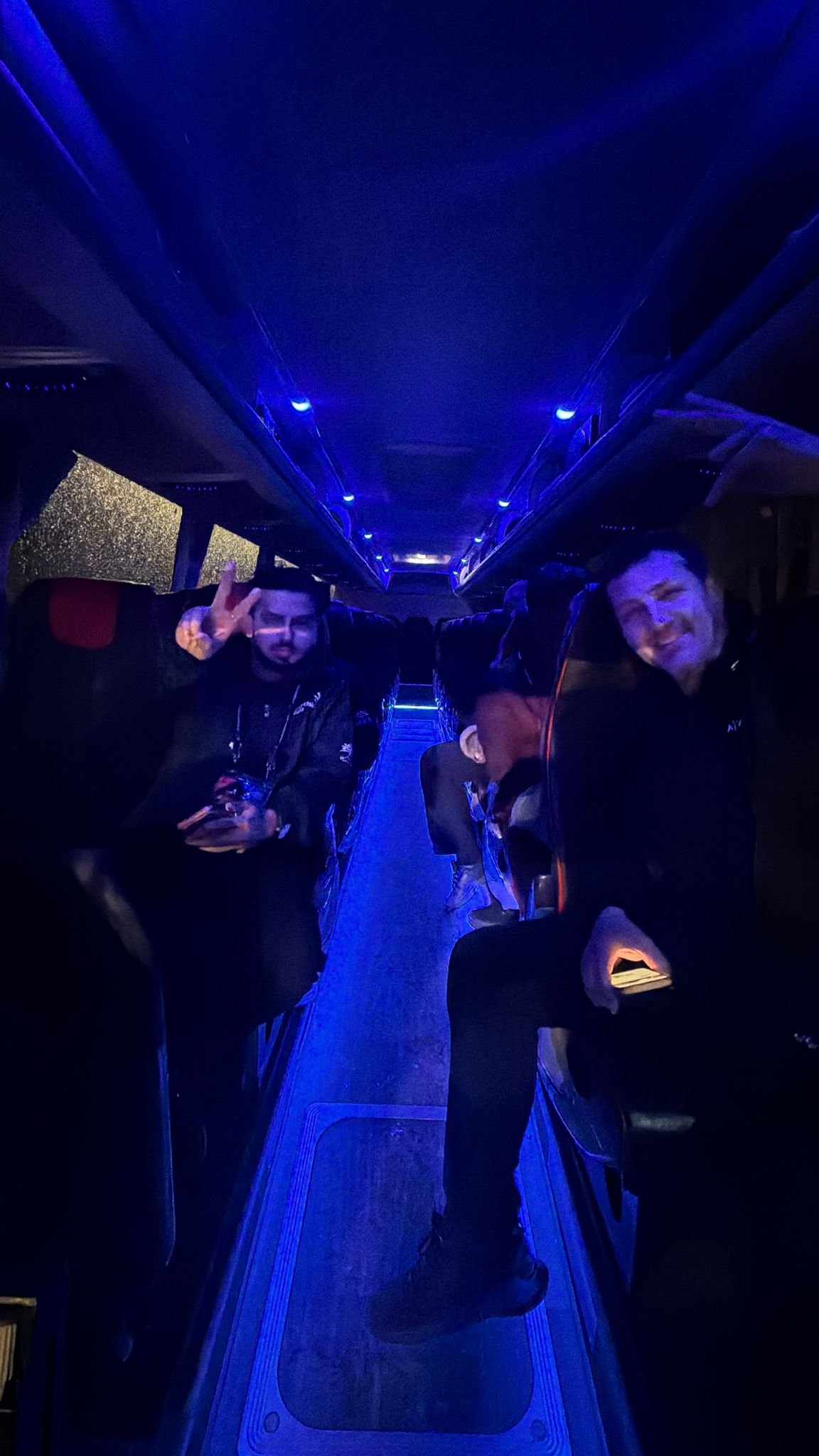 Colleagues on a party bus with LED lighting playing office Christmas party games between venues in Sydney