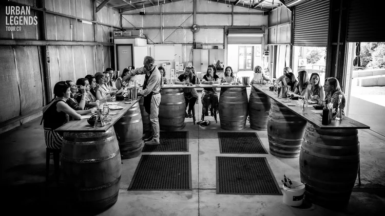 Group wine tasting in a barrel room