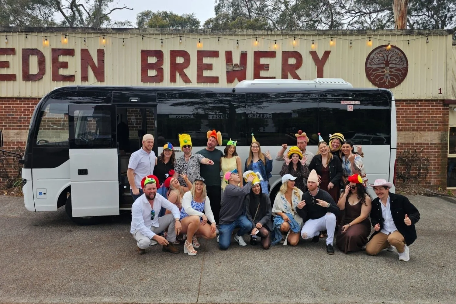 Large private tour group beside its charter bus at a brewery