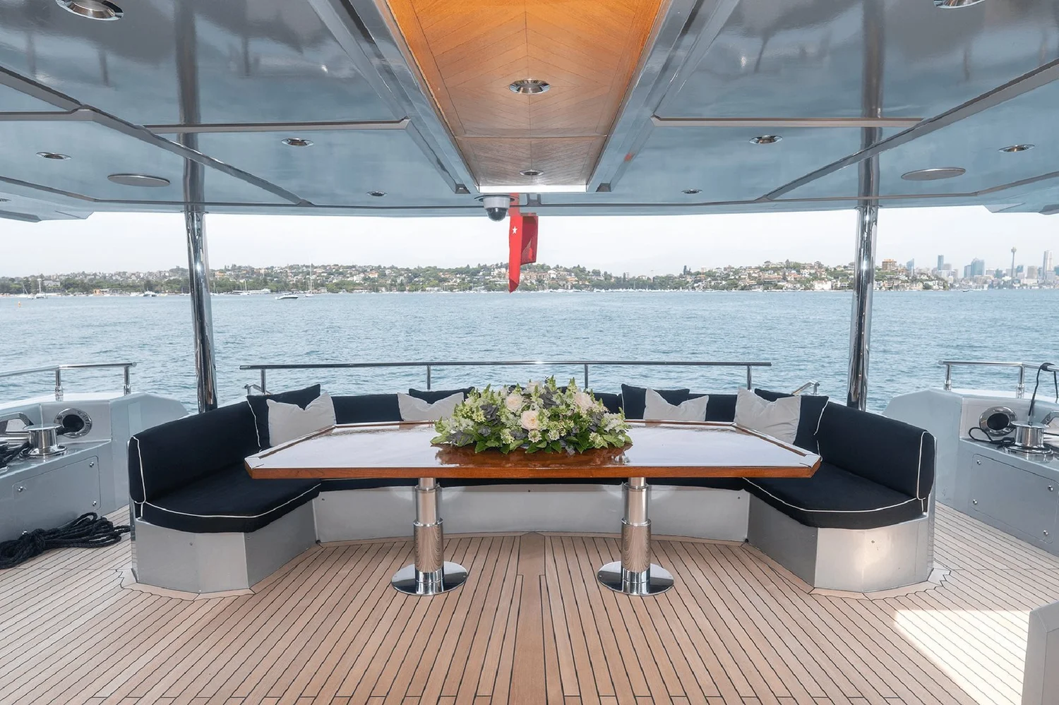 The aft deck dining table on the superyacht Ghost 2, looking out over Sydney Harbour