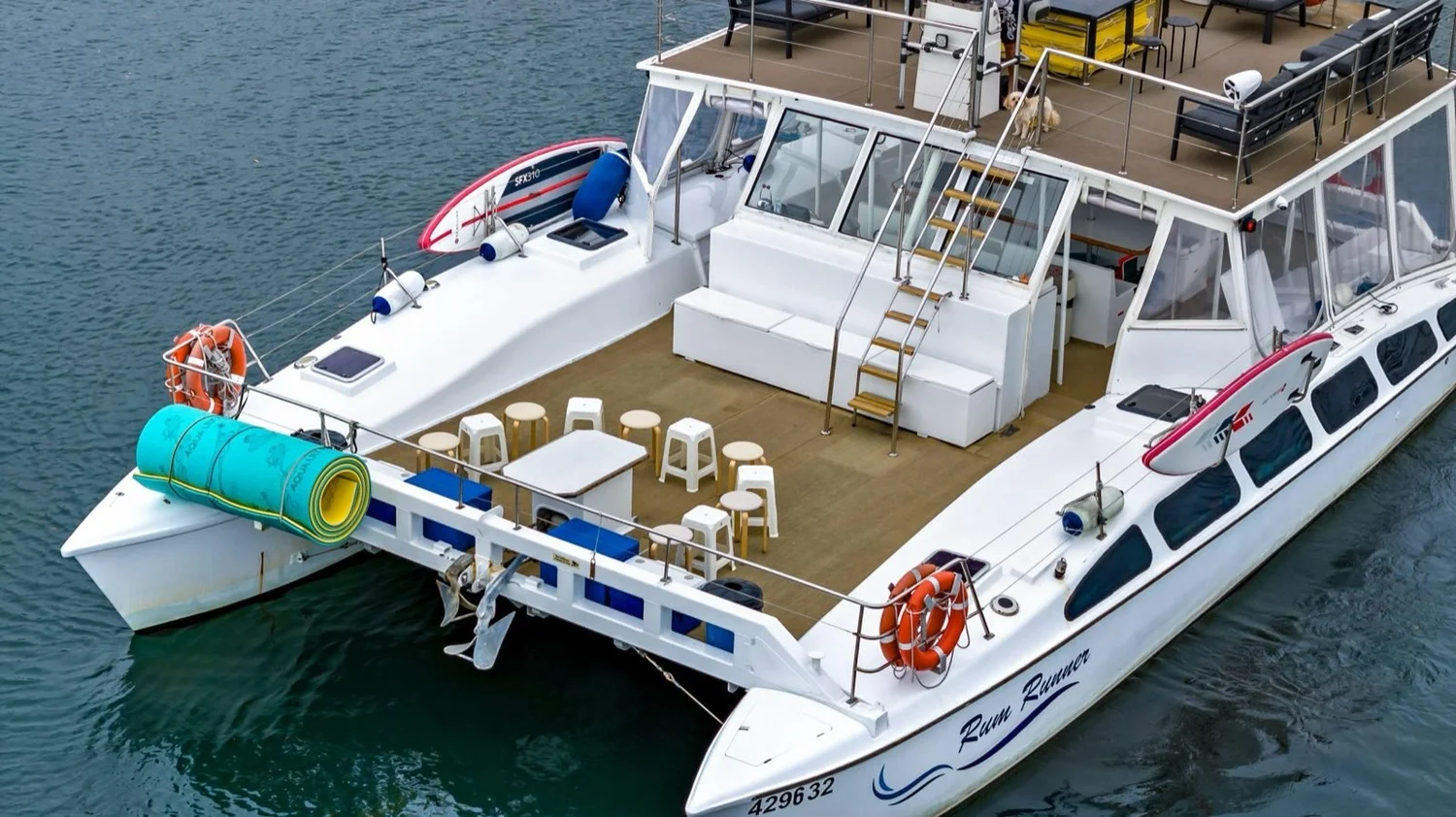Rum Runner party catamaran seen from above on Sydney Harbour, with the deck set up for a private charter