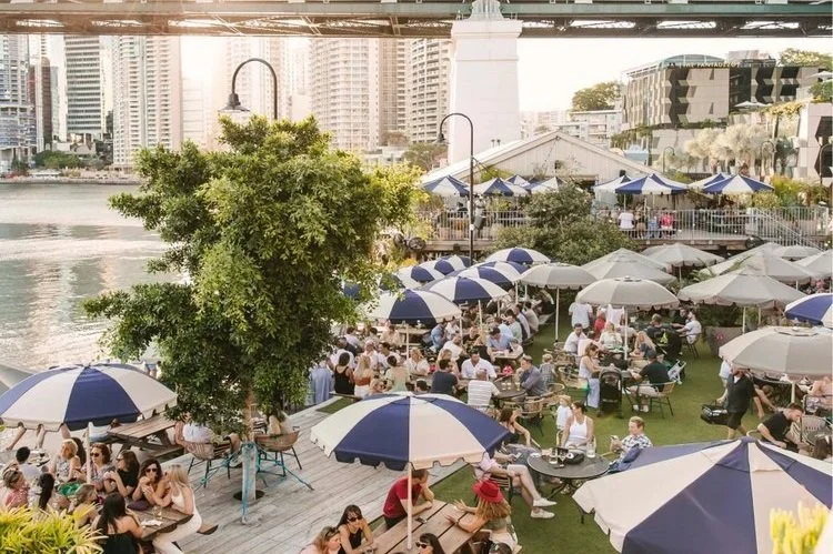 Guests at a riverside Brisbane bar precinct under the Story Bridge