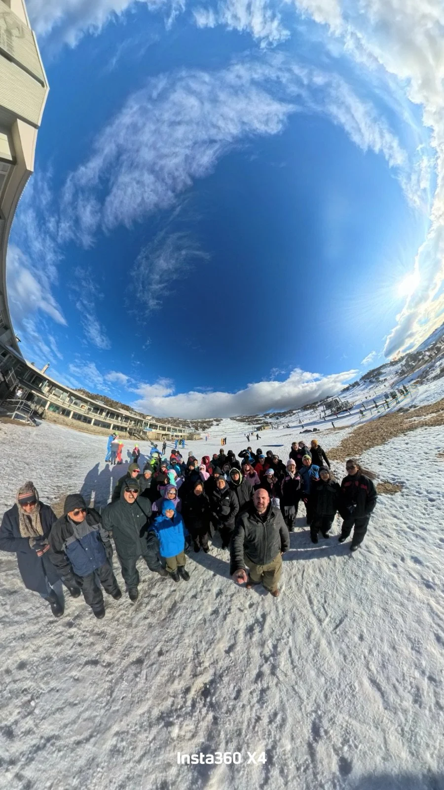 Tour group celebrating a bluebird day at Perisher on a group snow trip in Australia