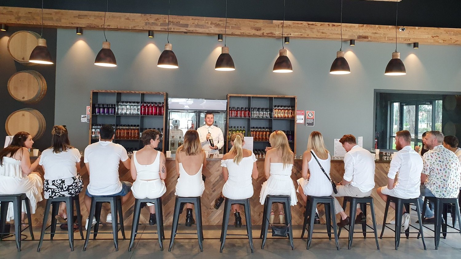 Work group tasting along the bar at a Hunter Valley distillery on a Christmas party day out