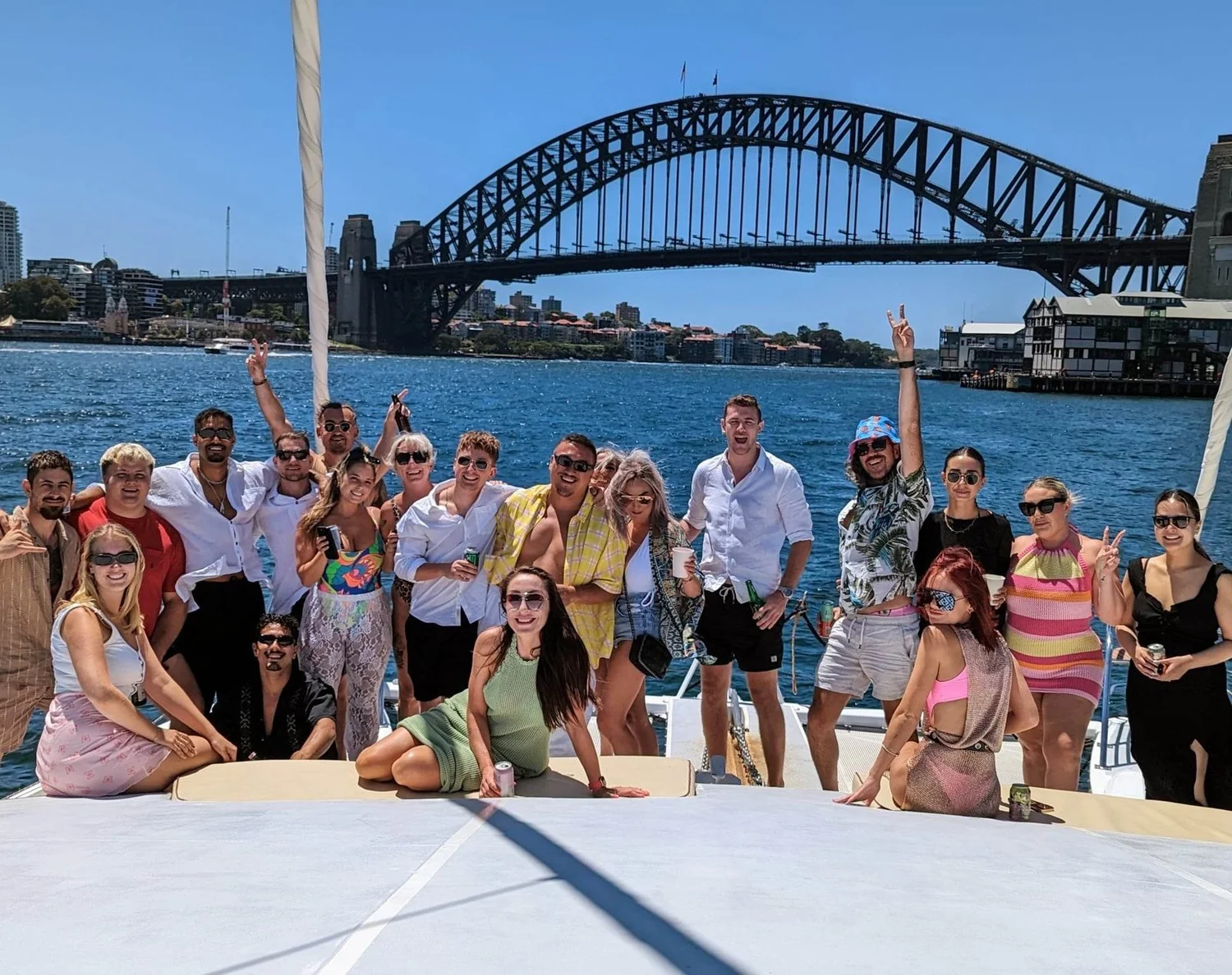 A group celebrating on the deck of Passion with the Sydney Harbour Bridge behind