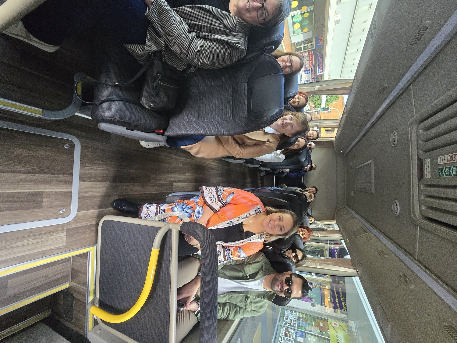 Work group seated aboard an Urban Legends bus between venues on a Sydney Christmas brewery crawl