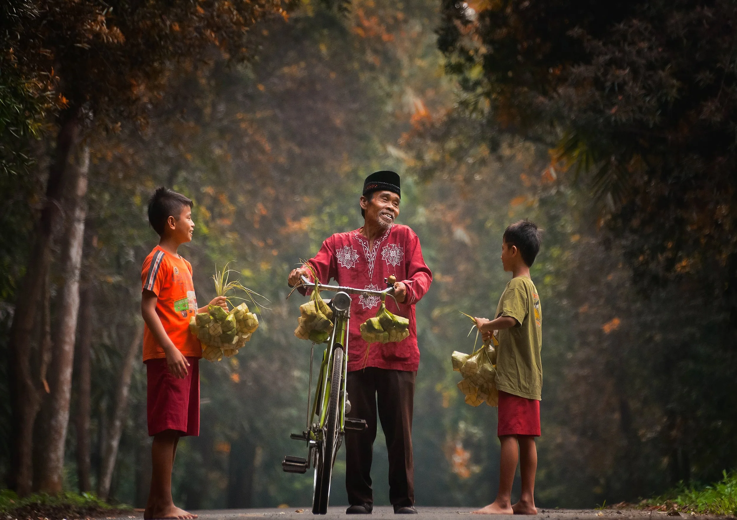 Winning photograph by Etha Ngabito, Indonesia - elder with bicycle and boys carrying Eid ketupat